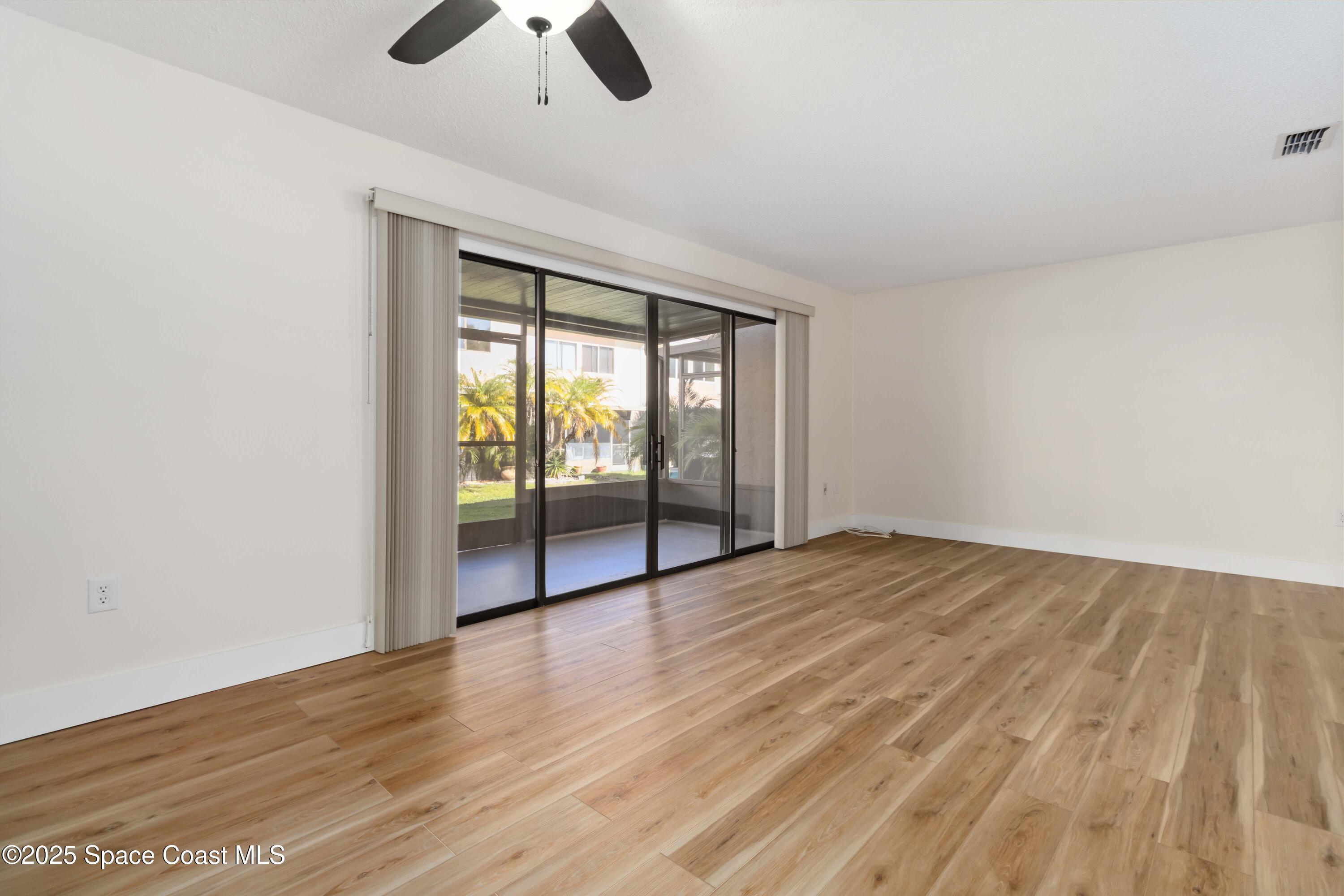 182 Bluefish Place, Unit 710 Rockledge, FL 32955 - Photo 12 of 33 wooden floor in an empty room with a window