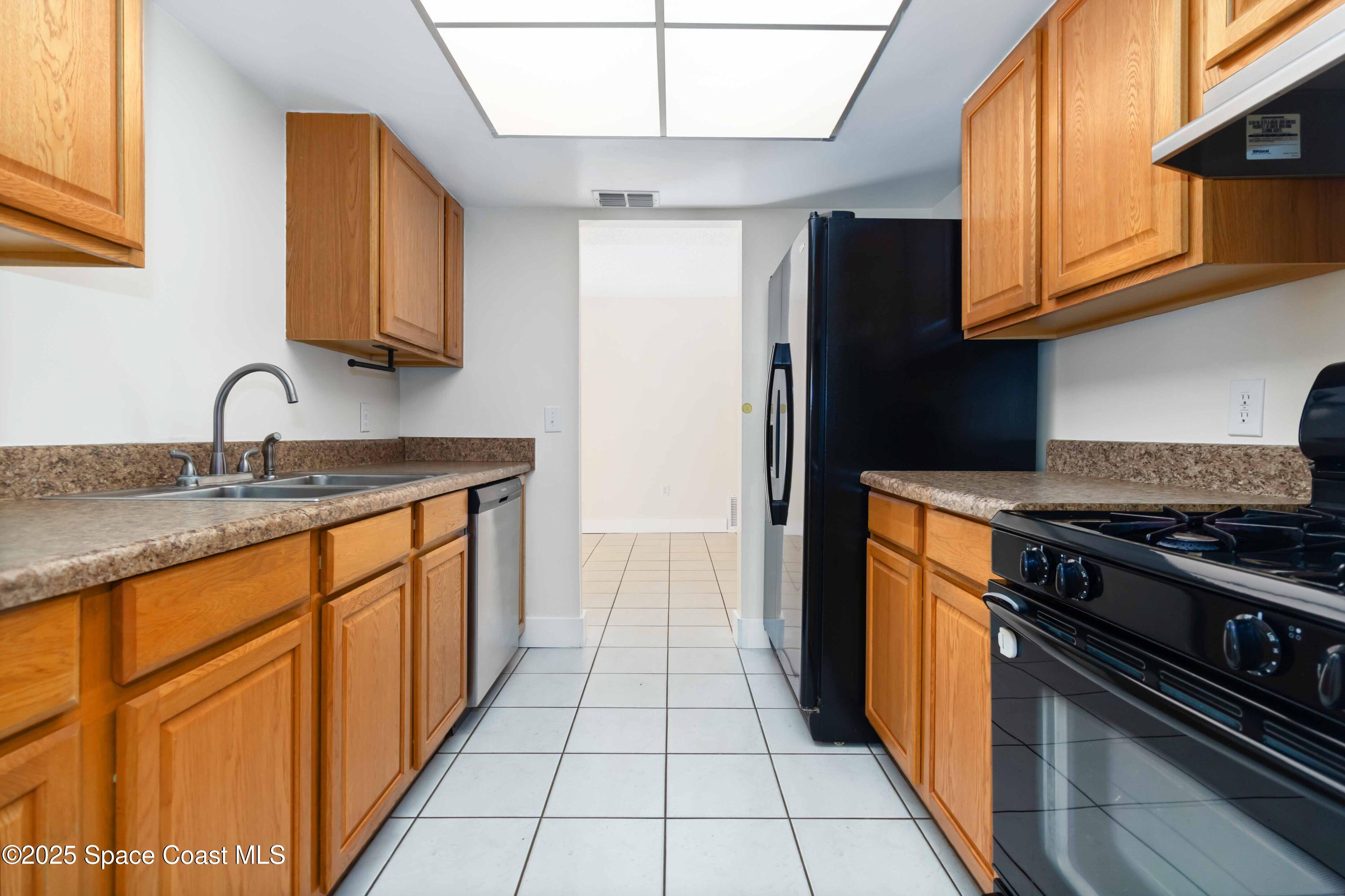 182 Bluefish Place, Unit 710 Rockledge, FL 32955 - Photo 13 of 33 a kitchen with stainless steel appliances granite countertop a stove a sink and a refrigerator