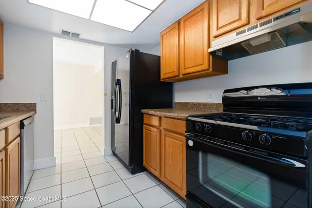 a kitchen with granite countertop a stove and a refrigerator