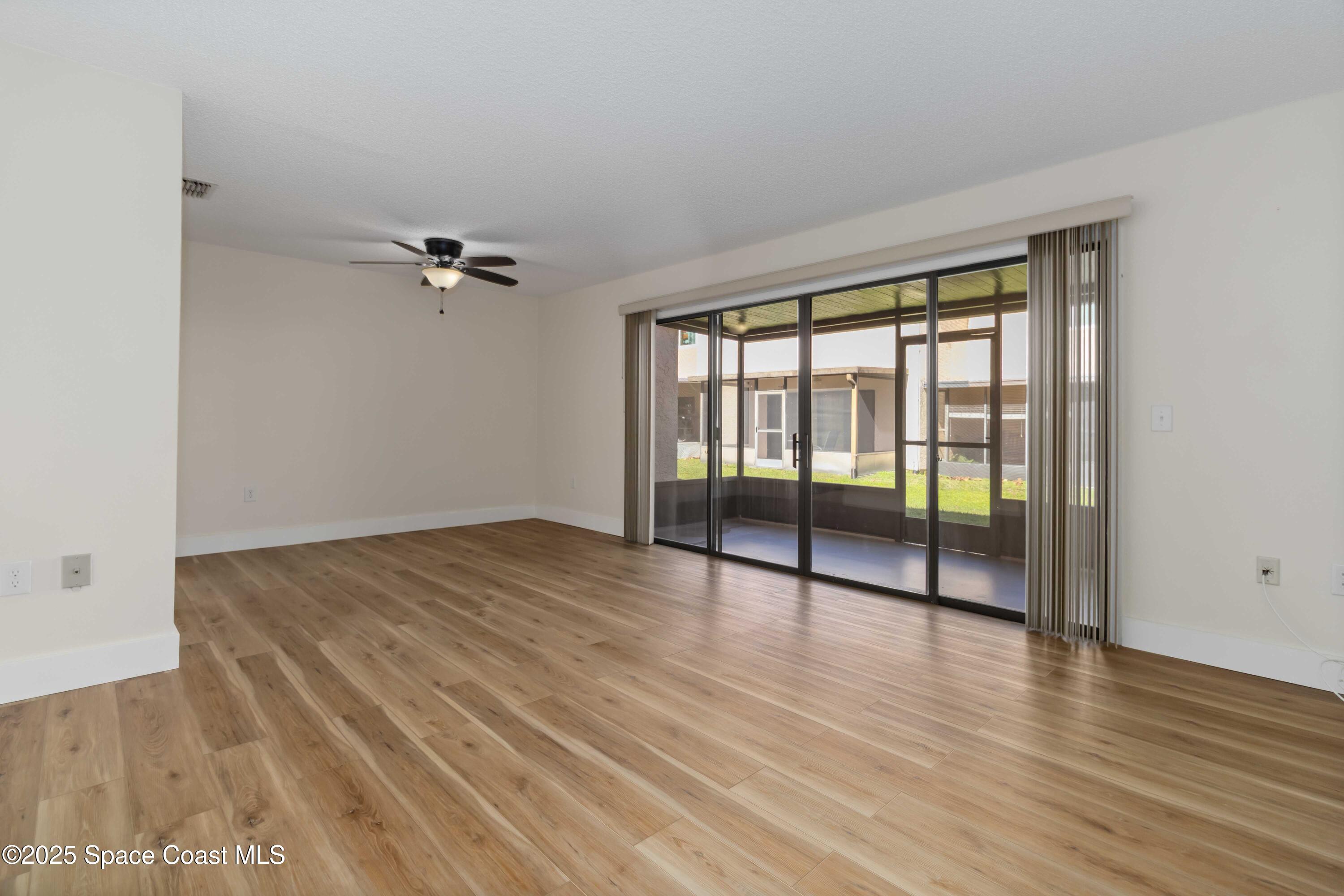 182 Bluefish Place, Unit 710 Rockledge, FL 32955 - Photo 9 of 33 wooden floor in an empty room with a window