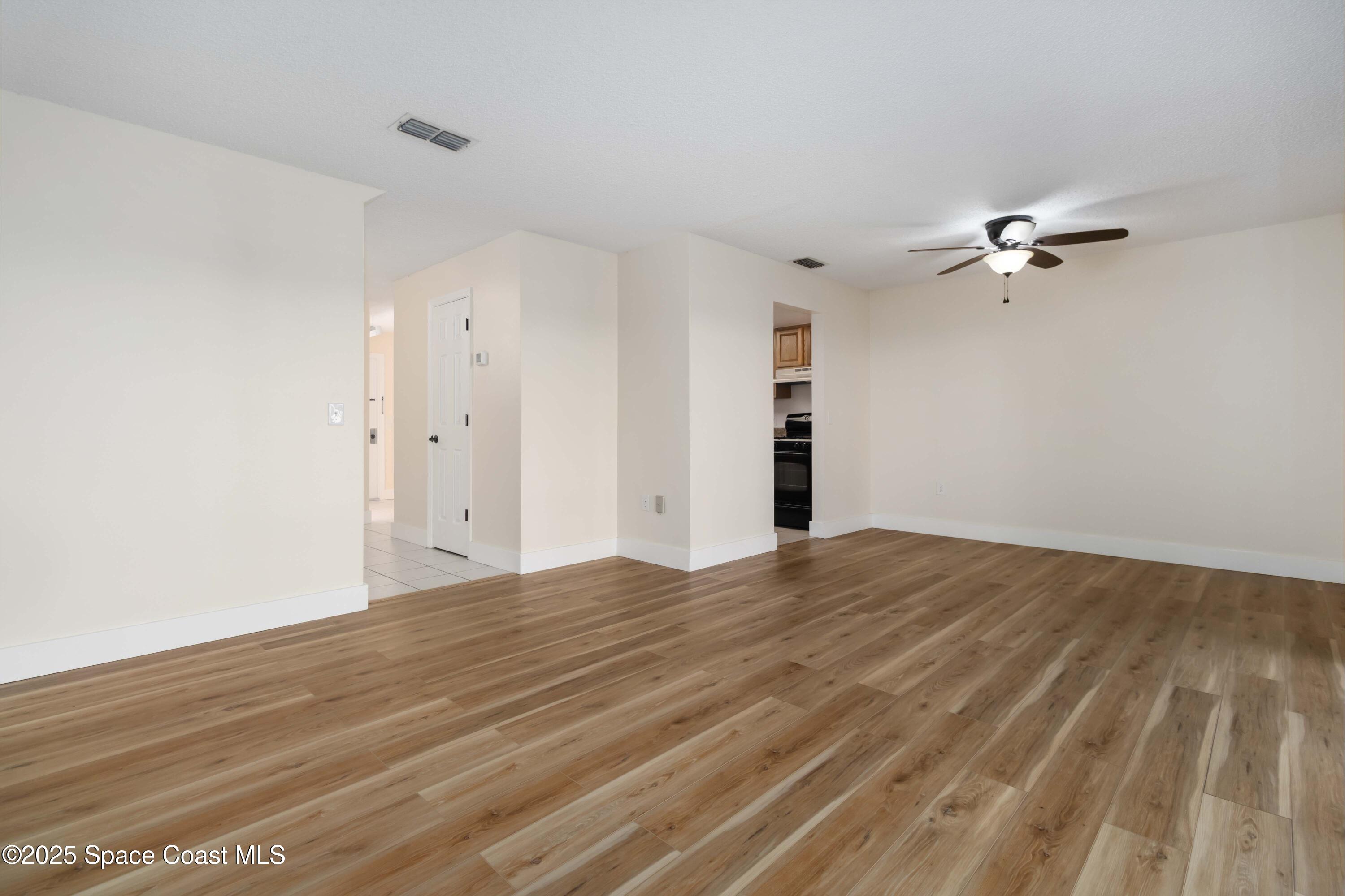 182 Bluefish Place, Unit 710 Rockledge, FL 32955 - Photo 10 of 33 a view of empty room with wooden floor and fan
