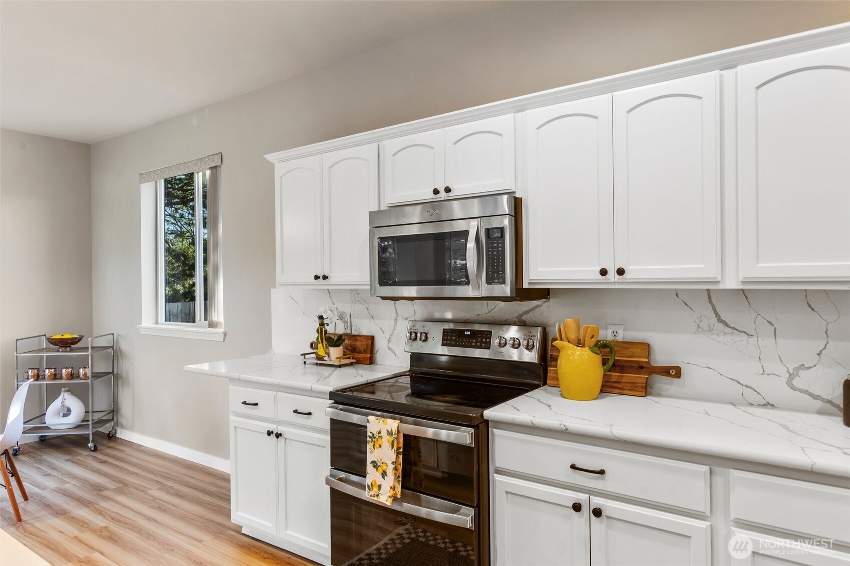 6203 Northeast 4th Circle Renton, WA 98059 - Photo 19 of 40 a kitchen with stainless steel appliances a stove a microwave a sink and cabinets