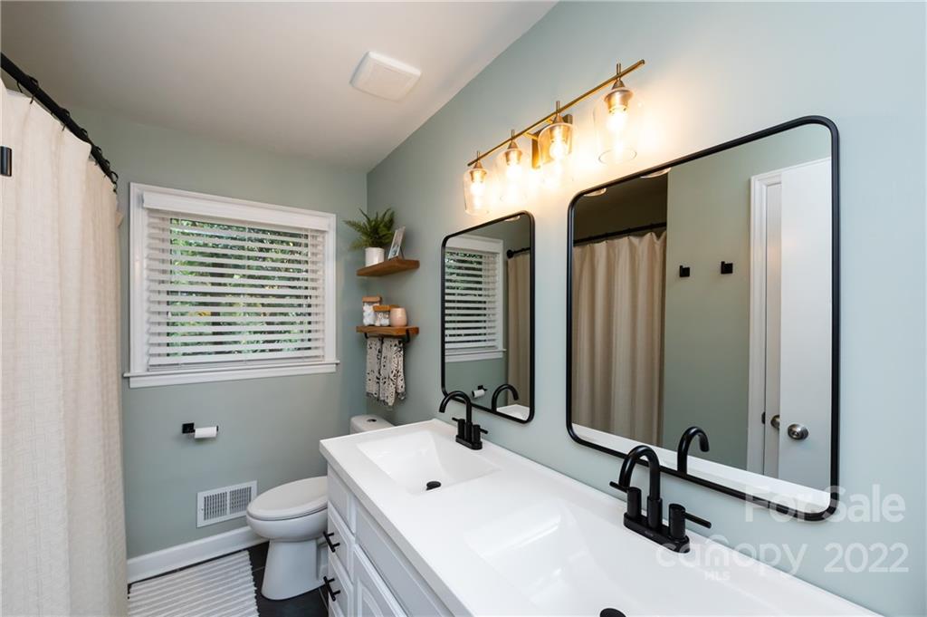 6409 Montpelier Road Charlotte, NC 28210 - Photo 10 of 35 a bathroom with a sink a toilet and a mirror