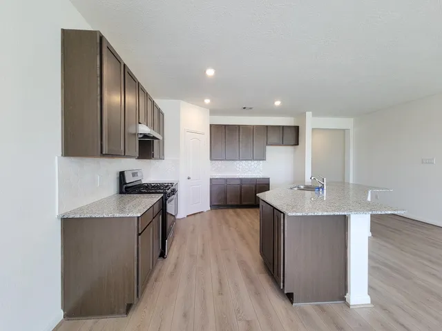 a kitchen with wooden cabinets and a stove top oven