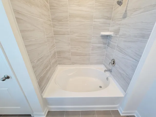 a bathroom with a tub sink and mirror