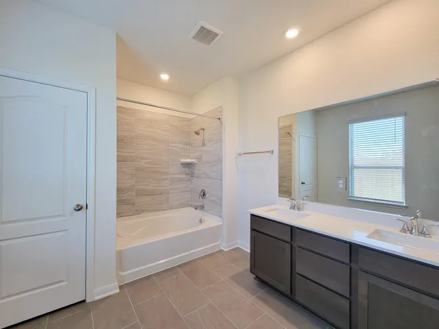 a view of an empty room with wooden floor and window