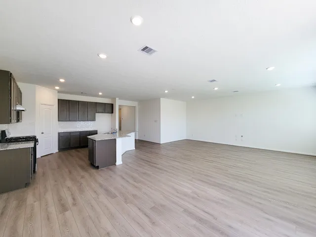an empty room with wooden floor and a window