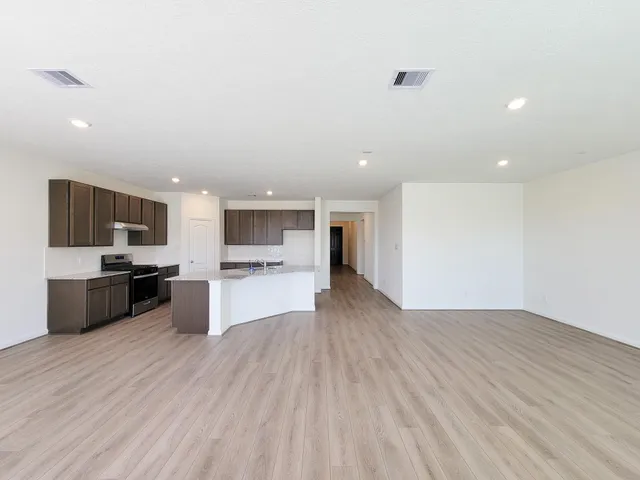 a kitchen with kitchen island granite countertop a sink counter top space and stainless steel appliances