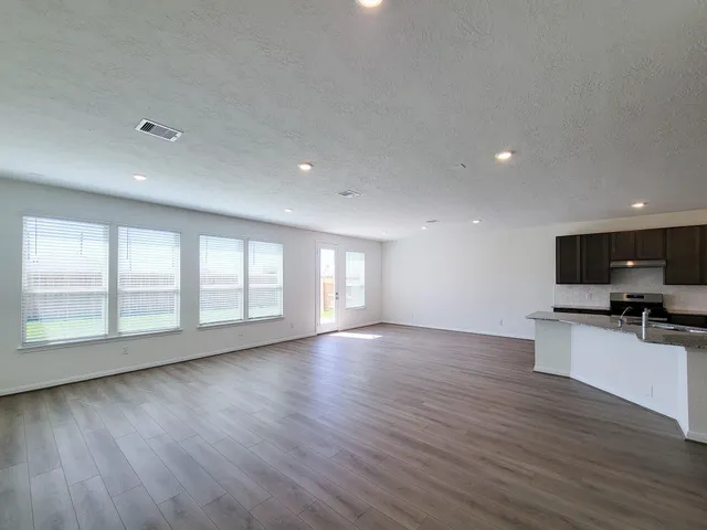 a kitchen with kitchen island granite countertop stainless steel appliances a sink stove and refrigerator