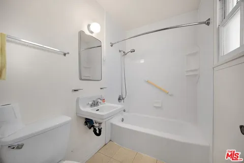 an empty room with wooden floor cabinet and windows