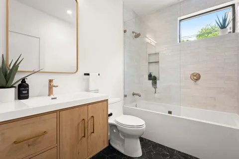 a bathroom with a sink a toilet and shower