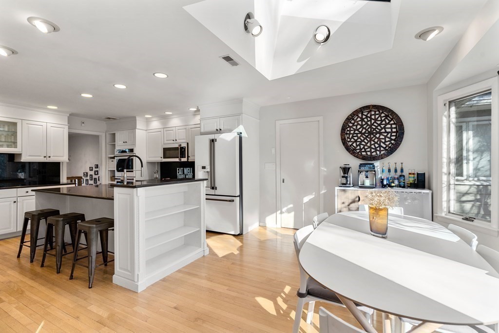 27 Grace Road Newton, MA 02459 - Photo 6 of 26 a kitchen with stainless steel appliances kitchen island granite countertop a refrigerator a stove a sink and a dining table with wooden floor