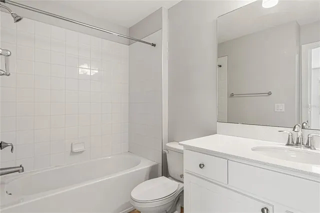a bathroom with a bathtub shower sink vanity and toilet