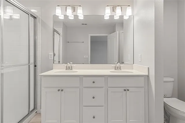 a bathroom with double sink and a mirror