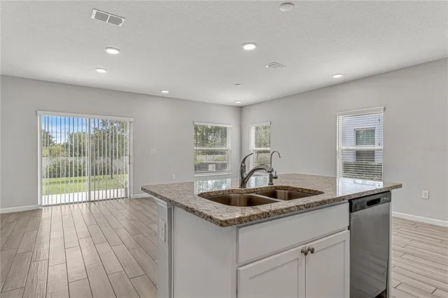 a kitchen with a sink and wooden floor