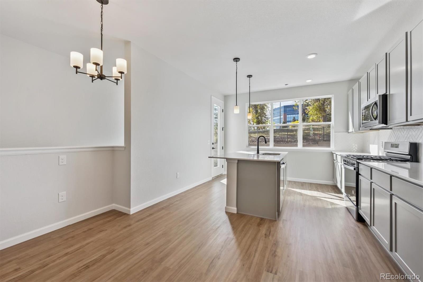 451 Interlocken Boulevard, Unit 101 Broomfield, CO 80021 - Photo 2 of 17 a kitchen with stainless steel appliances granite countertop wooden floors and sink