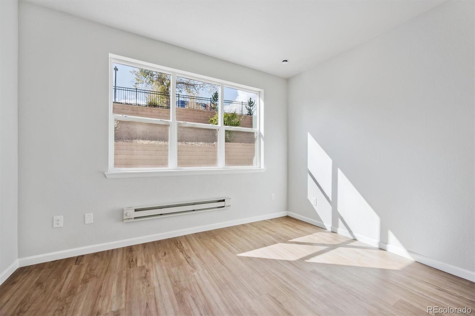 451 Interlocken Boulevard, Unit 101 Broomfield, CO 80021 - Photo 6 of 17 a view of empty room with wooden floor and fan