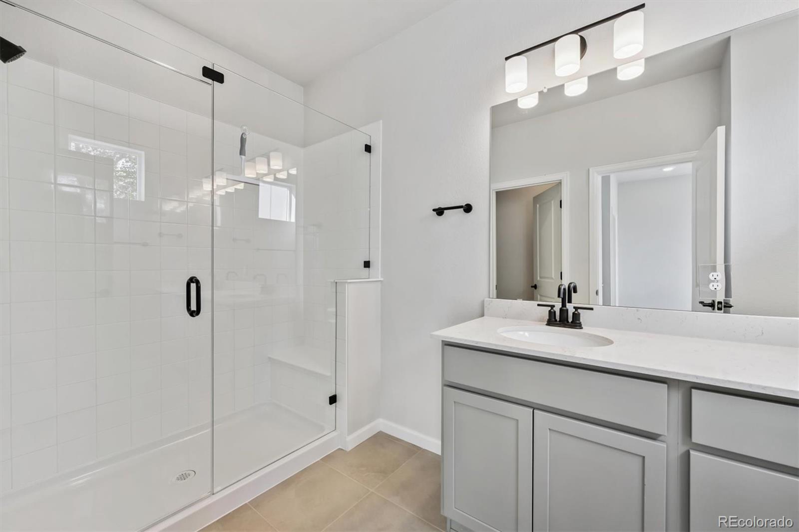 451 Interlocken Boulevard, Unit 101 Broomfield, CO 80021 - Photo 10 of 17 a bathroom with a shower sink and mirror