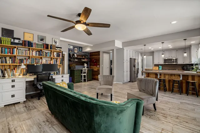 a kitchen with stainless steel appliances kitchen island granite countertop a table chairs and a couch