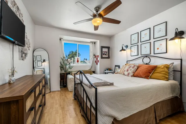 a bedroom with a bed a flat screen tv and dresser