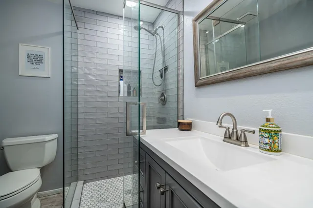 a bathroom with a sink a toilet and shower