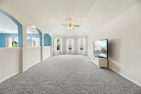 a view of an empty room with a window and a kitchen