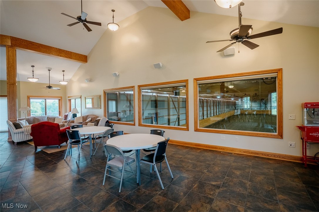 36328 Eagleton Road Lisbon, OH 44432 - Photo 34 of 49 Dining space with ceiling fan, baseboards, high vaulted ceiling, beamed ceiling, and stone finish flooring