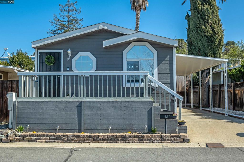 a view of a house with a small yard and wooden fence