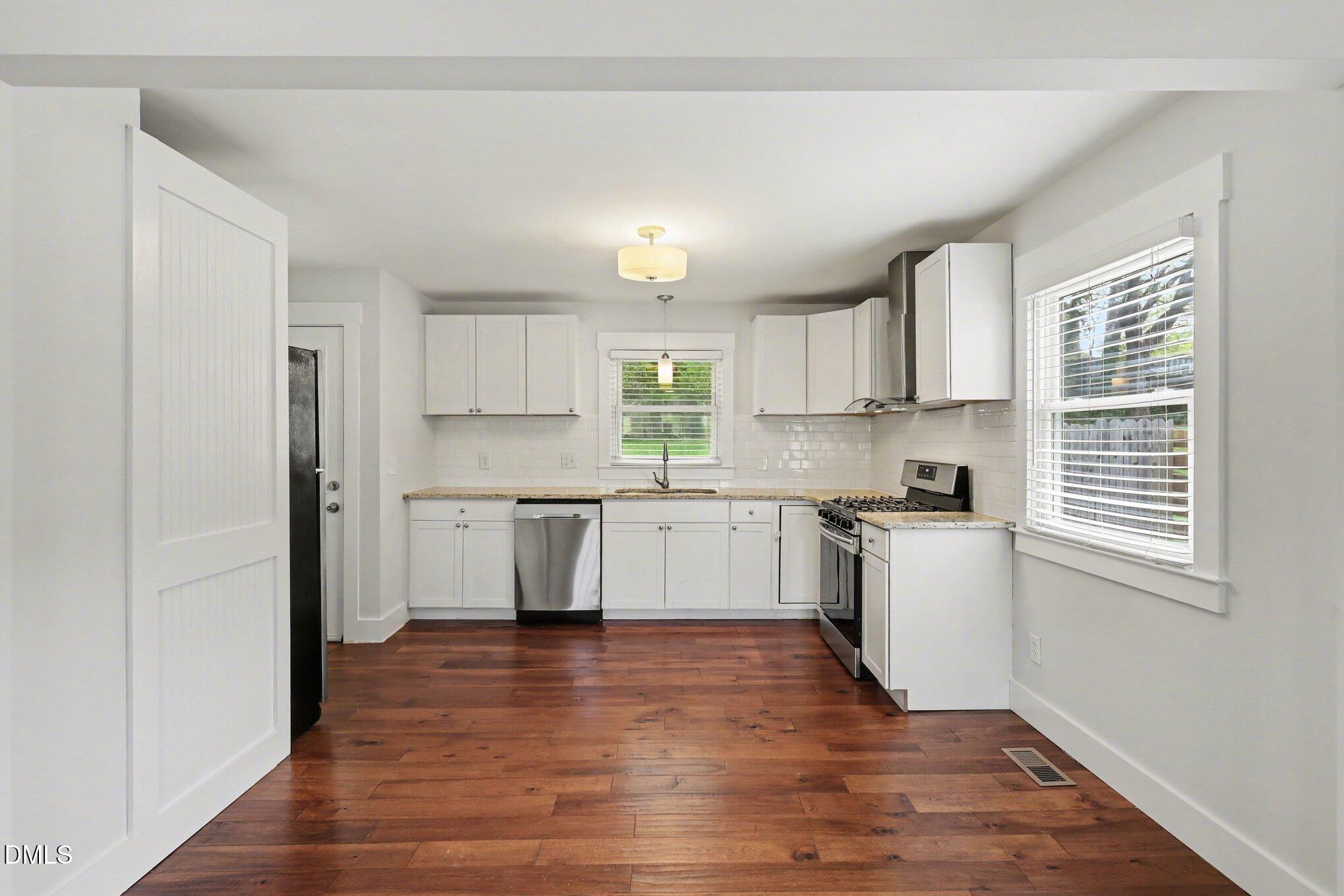 727 South State Street Raleigh, NC 27601 - Photo 8 of 30 a kitchen with granite countertop white cabinets and wooden floor