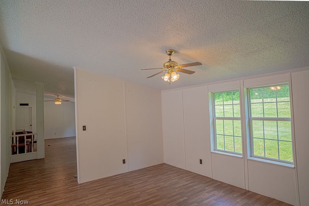 967 Buck Run Road Mineral Wells, WV 26150 - Photo 13 of 50 Interior space featuring wood-finish flooring, white paneling, and a ceiling fan with integrated lighting