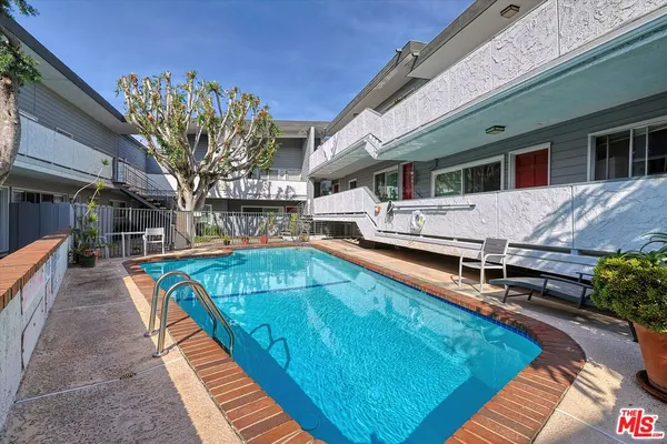 a view of a house with pool and chairs