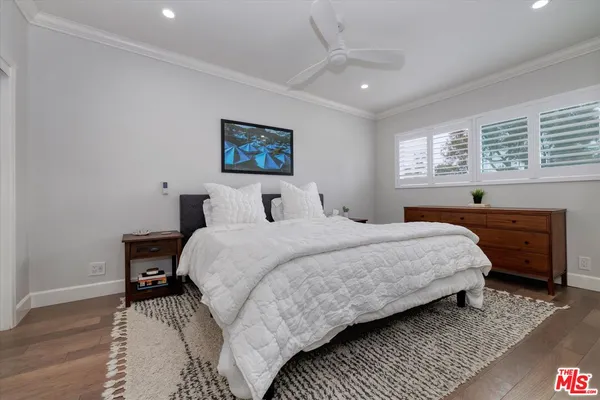 a bedroom with a bed and a painting on the wall