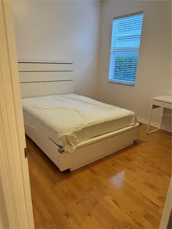 a bed sitting in a bedroom next to a window