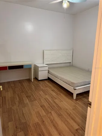 a view of a room with gym equipment and wooden floor
