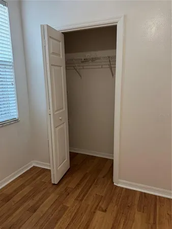 an empty room with wooden floor and closet