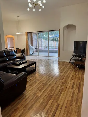 a living room with furniture a flat screen tv and a floor to ceiling window