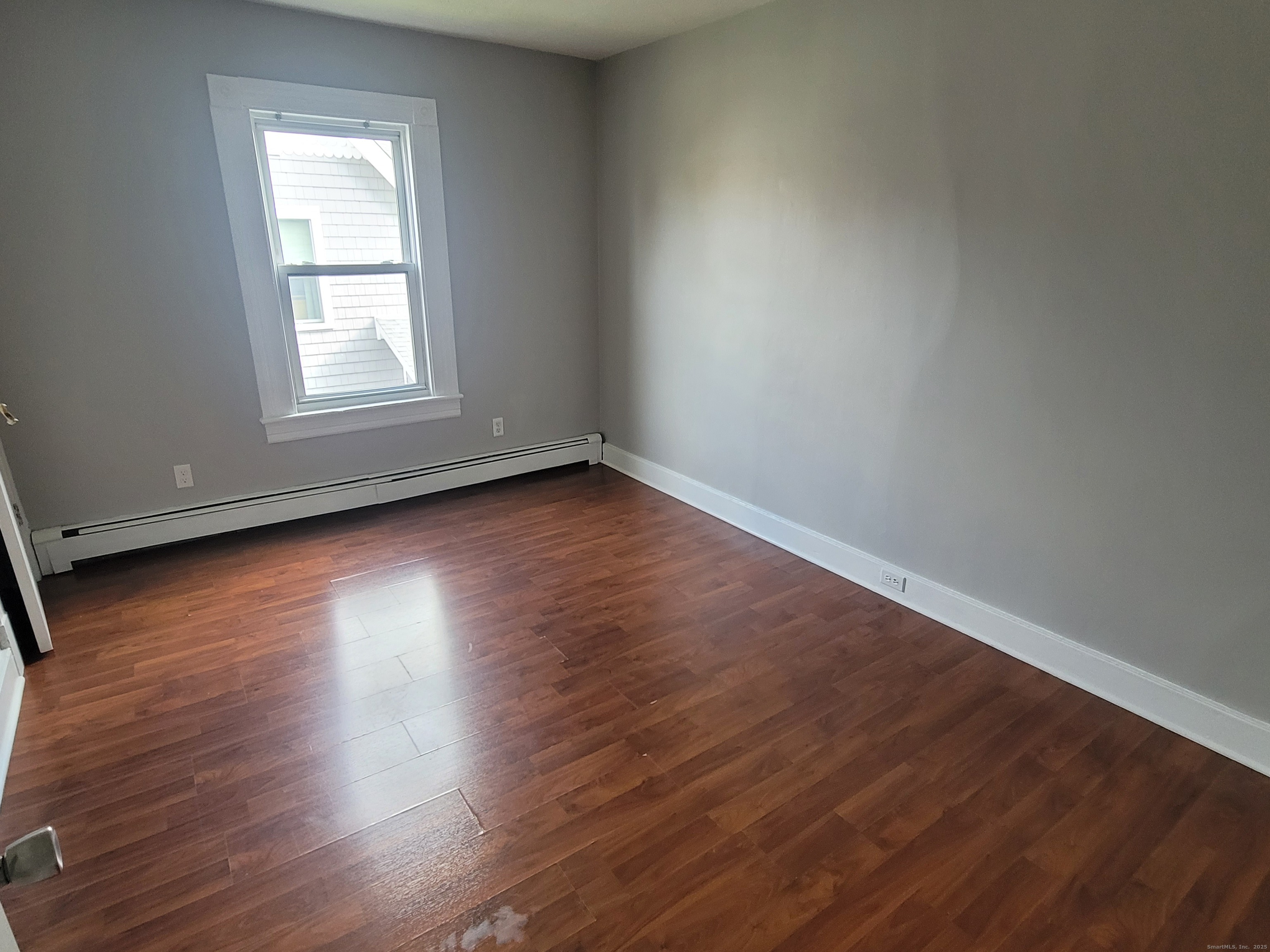 36 5th Street, Unit A Norwalk, CT 06855 - Photo 10 of 15 an empty room with wooden floor and windows