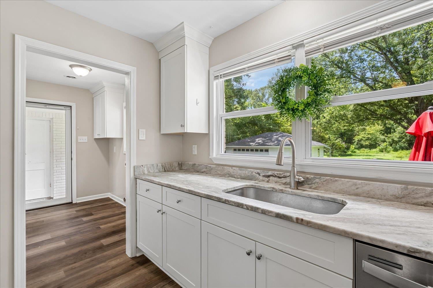 3351 Oak Road Bartlett, TN 38135 - Photo 16 of 30 White shaker cabinetry, stone countertops, stainless steel sink, brushed nickel faucet, and wood-finish flooring