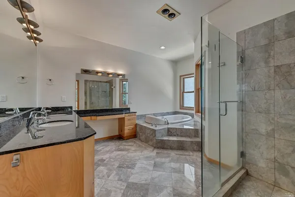 a large spacious bathroom with a granite countertop tub sink and mirror