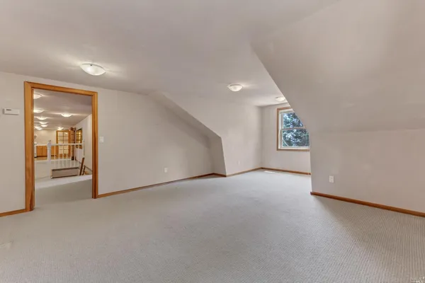 a view of a big room with windows and chandelier fan