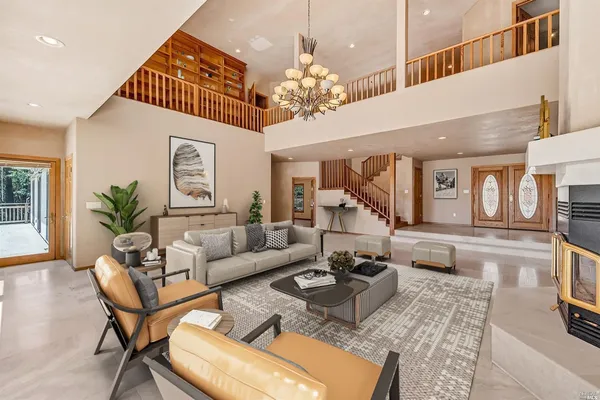 a living room with furniture a chandelier and a dining table