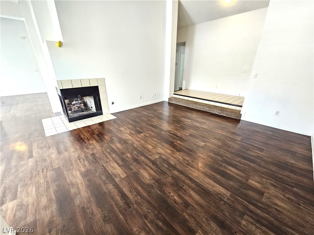 2817 Albemarle Way Henderson, NV 89014 - Photo 10 of 25 A well-lit living area features a charming fireplace with tile surround and rich wood flooring.