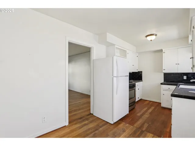 a kitchen with stainless steel appliances a refrigerator and a stove top oven