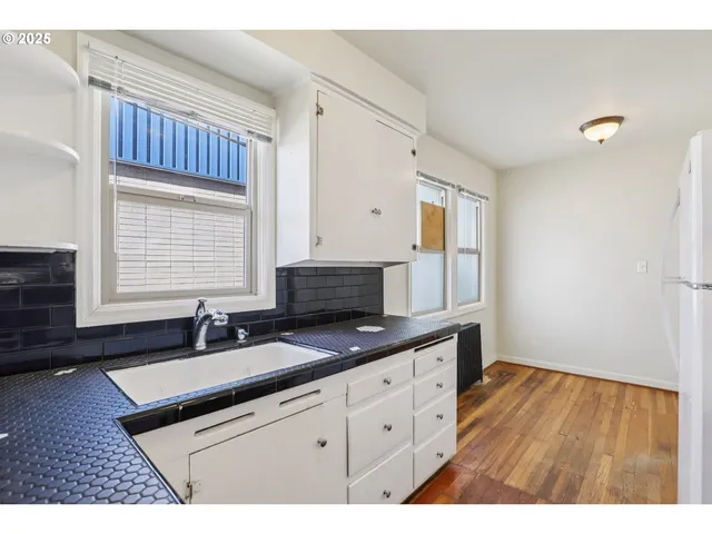 a kitchen with granite countertop a sink cabinets and window
