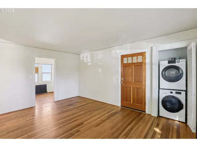 a view of empty room with wooden floor and window