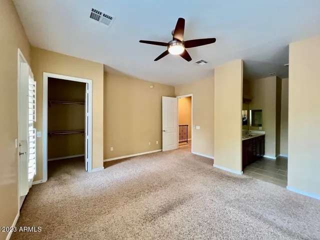 a view of a livingroom with a ceiling fan & entryway