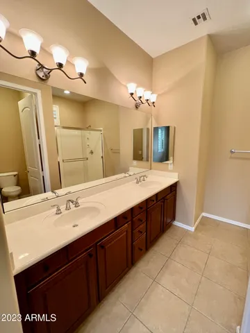 a bathroom with a double vanity sink a mirror and a bathtub