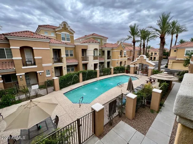 a view of a house with pool and chairs