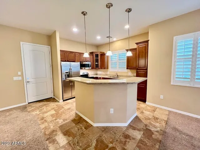 a view of kitchen with stainless steel appliances granite countertop cabinets and refrigerator