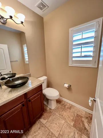 a bathroom with a granite countertop sink toilet and mirror
